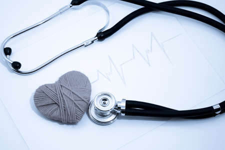 woven red heart and the stethoscope on the cardiogramの写真素材