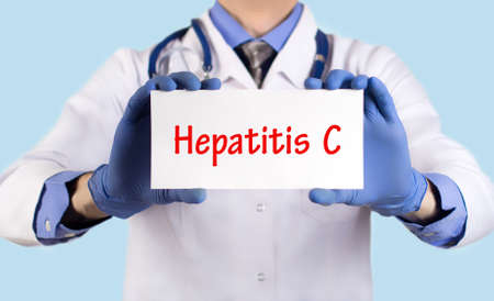 Doctor keeps a card with the name of the diagnosis ? hepatitis c. Selective focus. Medical concept.の写真素材