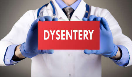 doctors hands in blue gloves shows the word dysentery.