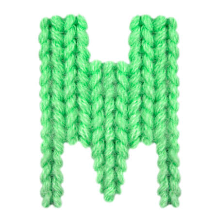 Letter M alphabet on a blurry texture knitted pattern of woolen thread closeup. One letter of the English alphabet. Education and holidays. Typography design. Color greenの写真素材