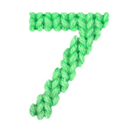 Number 7 (seven) alphabet on a blurry texture knitted pattern of woolen thread closeup. One figure...