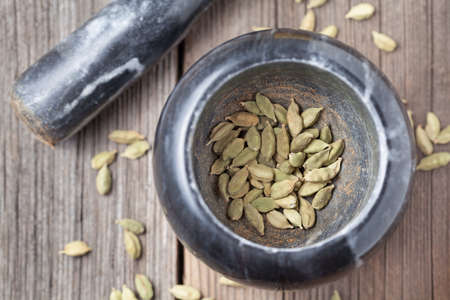Cardamom green seeds superfood ayurveda aroma spice in a mortar with pestleの写真素材