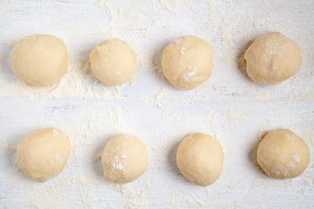 Rolled balls of dough on white tableの写真素材