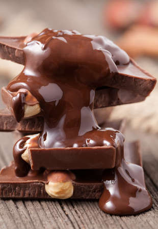 Stack of melted chocolate with nuts close up on wooden backgroundの写真素材