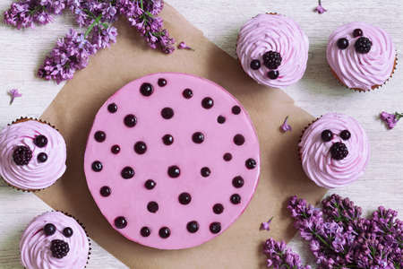 Traditional purple berry cupcakes with souffle dessert decorated with fresh berries on white kitchen...