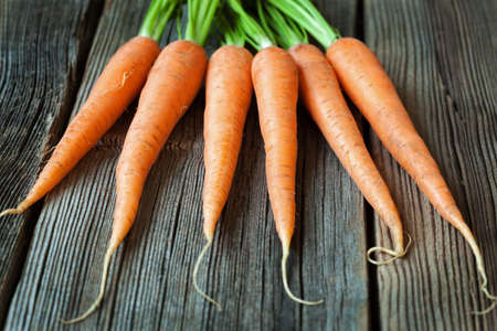 Carrots bunch of fresh organic vegetarian food on rustic wooden background. Rustic style and natural styleの写真素材