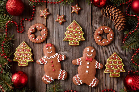 Gingerbread man and woman, fir trees, stars, christmas cookies composition with xmas tree decoration...