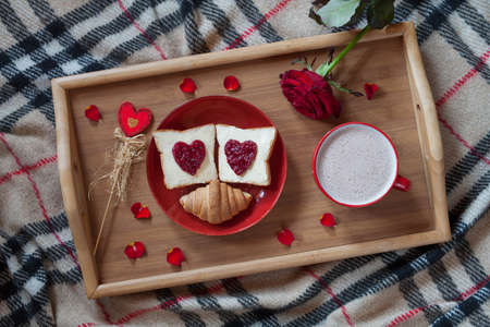 Valentines day breakfast in bed sweet romantic present, red rose flower. Two toasts with jam and hot...