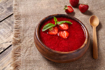 Healthy organic fresh strawberry cream soup vegetarian cold sweet berry smoothie summer food on rustic wooden background tableの写真素材