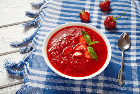 Natural organic fresh strawberry cream soup vegetarian cold sweet berry smoothie summer food on white wooden background tableの写真素材