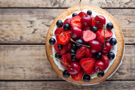 Fresh strawberry cake homemade traditional gourmet sweet dessert bakery food decorated with berries and whipped cream on rustic background tableの写真素材