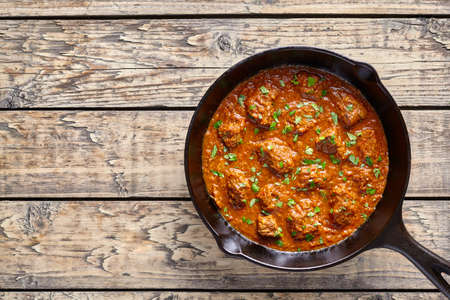Madras butter Beef curry Indian spicy sauce chili lamb meat food with rice garnish and tomatoes in...