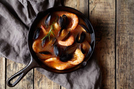 Bouillabaisse tomato seafood fish soup with prawns, mussels, lobster and squid. Traditional in France. Rustic wooden style.の写真素材