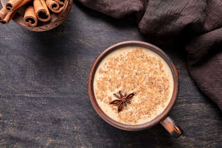 Milk tea chai latte traditional homemade refreshing morning organic healthy hot beverage drink with natural aroma spices blend in rustic clay cup on wooden table background.の写真素材