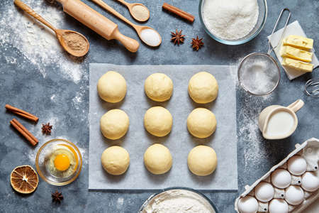 Buns dough homemade preparing recipe, ingridients food flat lay on kitchen table background. Working with butter, milk, yeast, flour, eggs, sugar pastry or bakery cooking.の写真素材