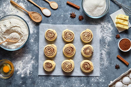 Cinnamon rolls dough preparation sweet traditional dessert buns pastry food baked homemade swirl Danish mini snack. Food ingridients flat lay on kitchen table. Top viewの写真素材