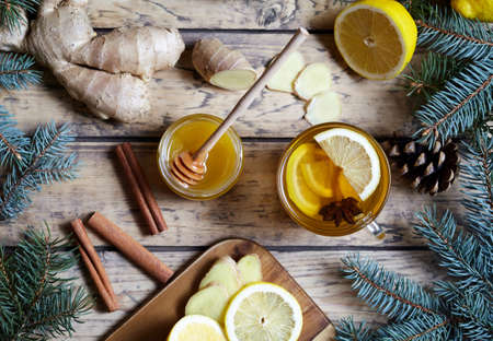 Cup of green natural ginger tea with lemon and honey on wooden rustic background. Healthy drink. Hot winter beverage concept.の写真素材