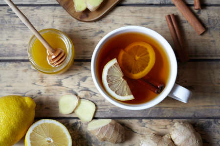 Antiviral Healthy drink useful tea with ginger, lemon and honey on wooden table. Healthy drink. Hot winter beverage concept.の写真素材