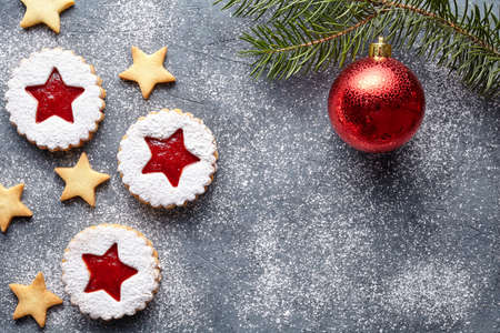 Linzer star cookies with jam filling with fir tree decorations flat lay traditional Christmas homemade Austrian sweet dessert food Xmas celebration pastry powdered holiday snack on vintage background.の写真素材
