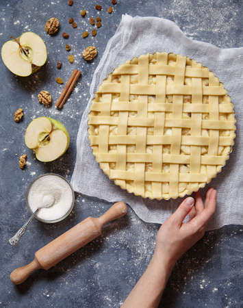 Apple pie tart homemade traditional autumn sweet pastry baked food cooking recipe with ingridients, rolling pin, egg yolk, sugar flat lay on blue vintage background, top viewの写真素材