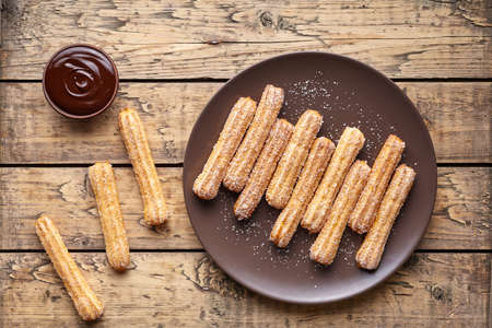 Traditional churros Spanish homemade sweet dessert pastry food on vintage wooden table backgroundの写真素材