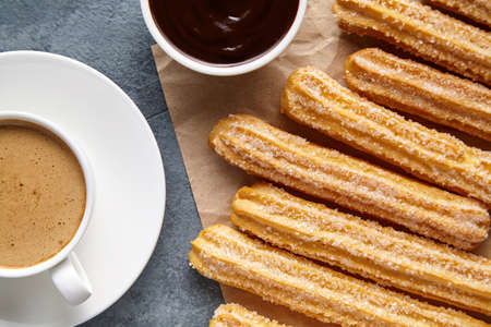 Churros Spain or Mexican breakfast meal street fast food dessert with cup of coffee and chocolate...
