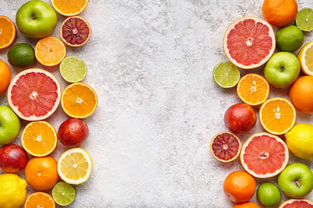 Fruit food background frame. Different citrus fruit on white concrete table. Healthy eating and diet. Antioxidant, detox, dieting, clean eating, vegetarian, vegan healthy lifestyle concept. Copy spaceの写真素材