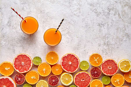Fresh juice or smoothie vitamin c drink in citrus fruits background flat lay, healthy lifestyle natural organic antioxidant detox diet beverage. Tropical summer assortment grapefruit, orange, appleの写真素材