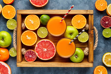 Different citrus fruit in a wooden tray and grey concrete table. Fruit food background.Antioxidant, detox, dieting, clean eating, vegetarian, vegan, fitness or healthy lifestyle concept. Flat lay.の写真素材