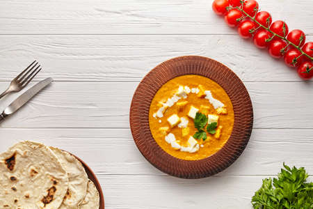 Shahi paneer Indian vegetarian masala gravy food with vegetables, parsley and white sauce