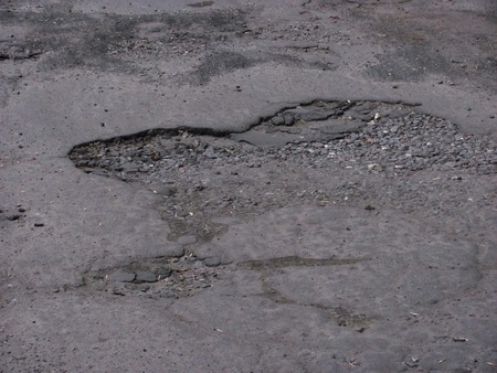 Damaged asphalt road with pothole. Bad road.の写真素材