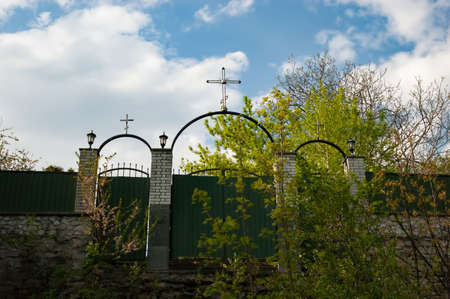 overgrown gate with an Orthodox cross, view from belowの写真素材