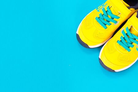 Pair of yellow shoes on blue background.Top view,flay lay,sale concept, sport, black friday