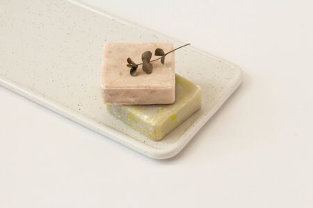 oliva and vanila Soap from soy wax with vsprig of eucalyptus on a white marble boardwhite background. Natural cosmetics. Ecological soap. Front view, selective focusの写真素材