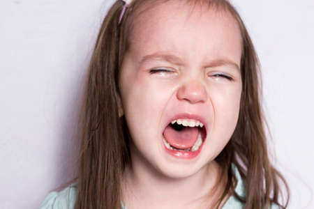 Kharkiv, Ukraine - March 20, 2020. emotion concept. pretty black-haired girl crying because of boredom in quarantine. pain, despair, tears, screaming, tantrum of a quarantined house.のeditorial素材