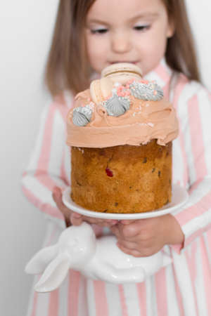 Kharkiv, Ukraine - march15, 2019.A happy little girl looking at an eastern cake.Easter concept.Traditional homemade easter and girl.Easter holidays breakfast concept.Traditional home cakeのeditorial素材