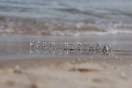 selective focus Happy birthday candles on a beach.sunny day at the seaside on a birthday. sea wave...