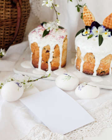 Pink Easter decorations: tulip flowers, basket with painted eggs and dotted rabbit figure on white wooden table.のeditorial素材