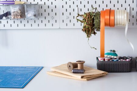 working sewing tools on the wall and table in the tailor's workshop in the atelier, the sewing...
