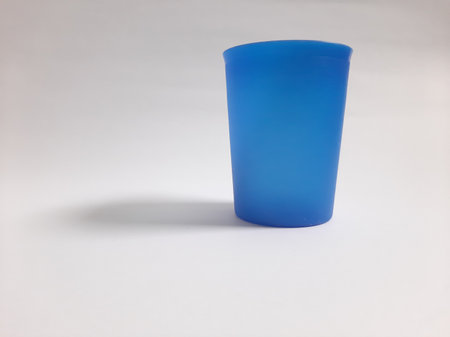 Side view empty plastic blue cup on isolated white backgroundの写真素材