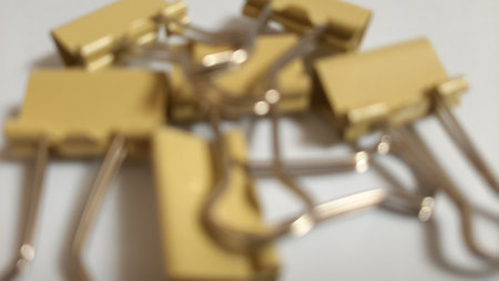 Blurred or unfocused or defocused Binder or paper clip or office bind clip, stationery, realistic object on isolated white backgroundの写真素材