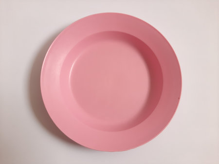 Top view empty plastic pink plate on isolated white backgroundの写真素材