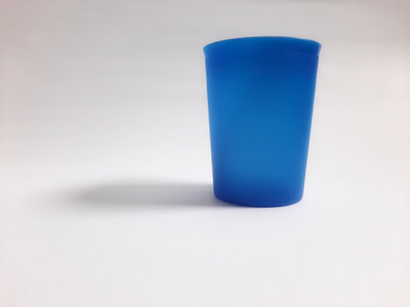 Side view empty plastic blue cup on isolated white backgroundの写真素材