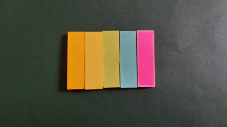 Pastel and Neon Sticky Notes or Paper Index or Page Marker or Flags Tabs or Note Adhesive Post Highlighter or Memo Pads for Highlighting Documents on Isolated Dark Backgroundの写真素材