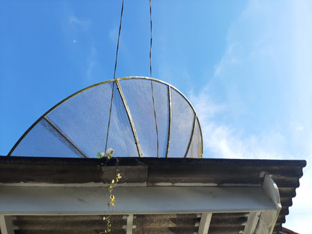 Blue sky with rooftop, cable, and transmitter on a shiny day and white ceiling. Copy space for text.の写真素材