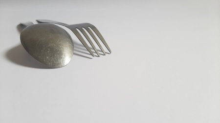 Metal or steel silver spoon and fork on isolated white background