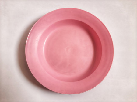 Top view empty plastic pink plate on isolated white backgroundの写真素材