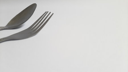 Metal or steel silver spoon and fork on isolated white backgroundの写真素材
