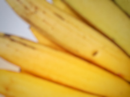 Blurred yellow bunch of banana close up on white backgroundの写真素材