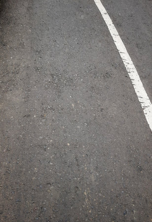 Asphalt highway texture background with one white stripe on the cornerの写真素材